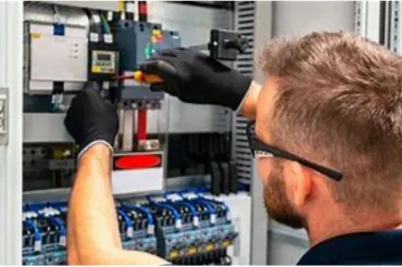 Técnico realizando manutenção em quadro elétrico
